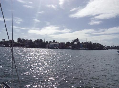 een boot in een lichaam van water met huizen bij Sailboat with view in Miami