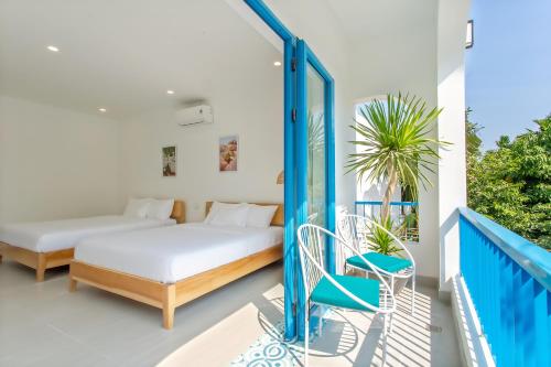 a balcony with a bed and a chair at Santorin HoiAn Villa in Hoi An