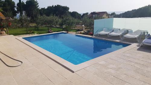 una gran piscina con sillas en Secluded Seaside Holiday Home en Milna