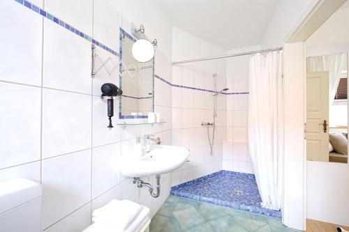 a white bathroom with a sink and a shower at Elbhof Harnisch in Bleckede