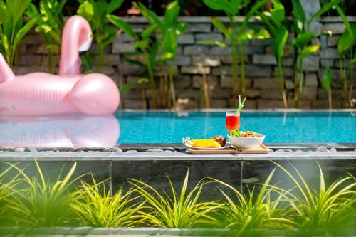 a tray of food sitting next to a swimming pool at Santorin HoiAn Villa in Hoi An