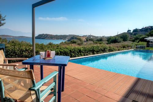 una mesa azul en una terraza junto a una piscina en Mirabella Apartments, en Agios Nikolaos