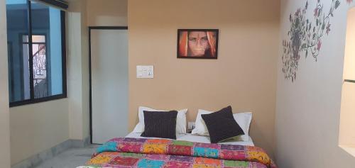 a bedroom with a bed and a picture on the wall at Swiss House in Jodhpur