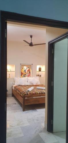 a bedroom with a bed with a painting on the wall at Swiss House in Jodhpur