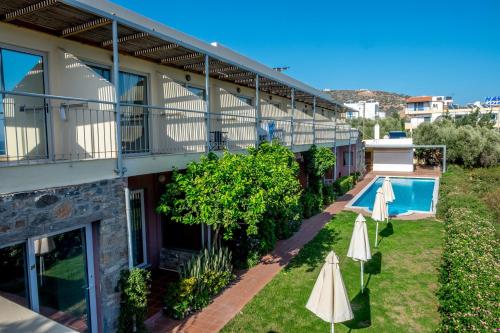 um apartamento com uma piscina e dois guarda-sóis em Mirabella Apartments em Agios Nikolaos