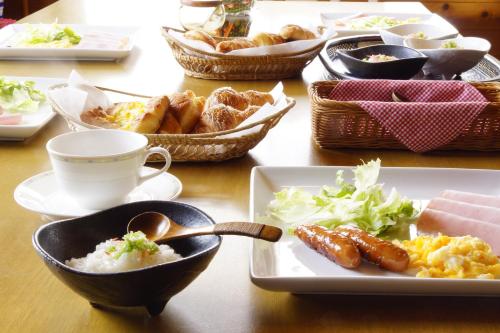 a table with plates of food and bowls of food at Do Sports Plaza Madarao in Iiyama