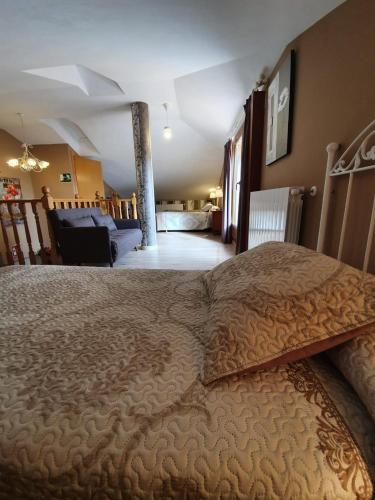 a bedroom with a large bed and a living room at Casa rural Los Bodones in Quintanilla Riopico