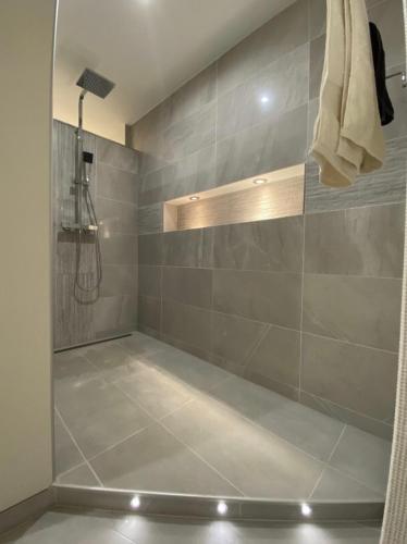 La salle de bains est pourvue d'une douche et de carrelage. dans l'établissement Appartement -Villa ROYAL, à Oberlauterbach