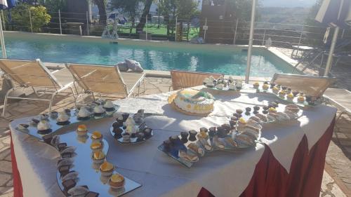 a table with a cake and plates of food on it at Albergo B&B Antica Trattoria Bacco in Circello