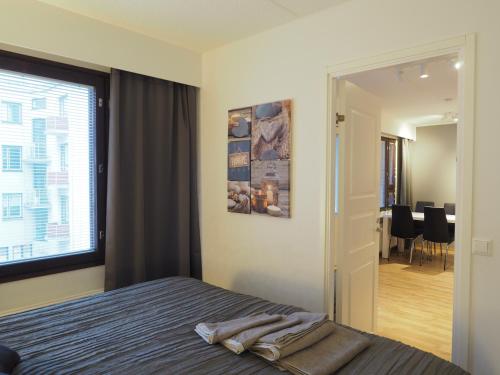 a bedroom with a bed and a large window at Apartment Oulu station II in Oulu