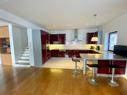 a kitchen with red cabinets and a kitchen island with bar stools at Chalet Das Atrium in Radstadt