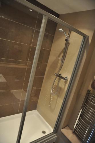 a shower with a glass enclosure in a bathroom at Luxury riverside apartment in Kendal in Kendal