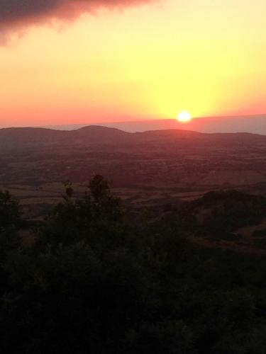 a sunset over a field with the sun in the sky at Stazzo La Foci soluzioni vista Mare in Aglientu