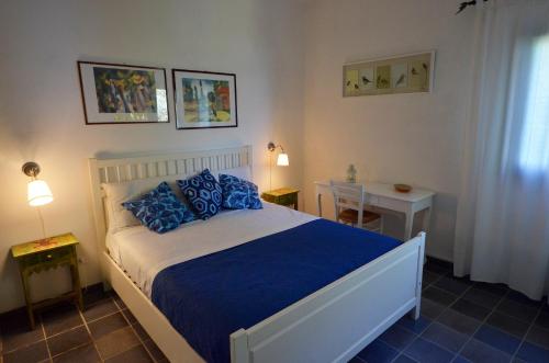 a bedroom with a large bed with blue pillows at Baglio La Luna - B&B in San Vito lo Capo