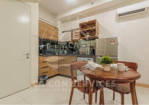 a dining room with a table and a kitchen at TimurBay Stunning By CA CON in Kuantan