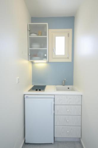 a white kitchen with a sink and a counter at Soula Naxos in Naxos Chora