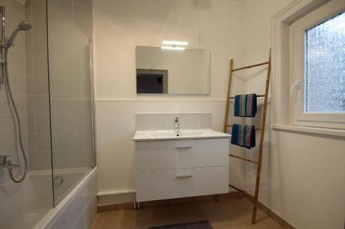 a bathroom with a sink and a shower and a mirror at Au bonheur d'Etretat in Étretat