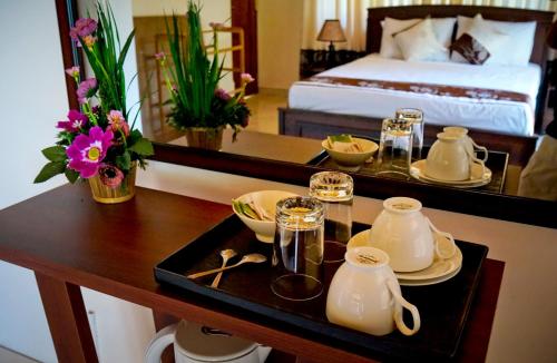 SUNSET HILLS في كاندي: غرفة الفندق مع طاولة عليها أطقم الشاي