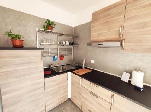 a small kitchen with wooden cabinets and a sink at Tric Trac Hostel in Naples
