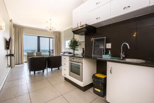 a kitchen with a counter and a dining room with the ocean at Point Waterfront Apartments in Durban