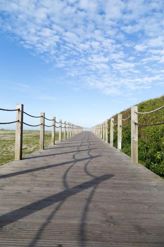 a long wooden boardwalk with a fence on it at Mar Rosa in Aguçadoura