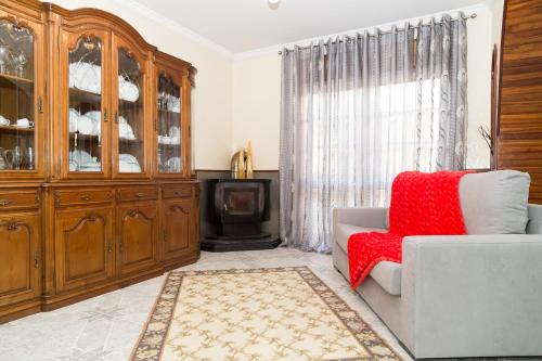 a living room with a couch and a wooden hutch at Mar Rosa in Aguçadoura