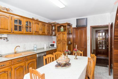 a kitchen with wooden cabinets and a table and chairs at Mar Rosa in Aguçadoura