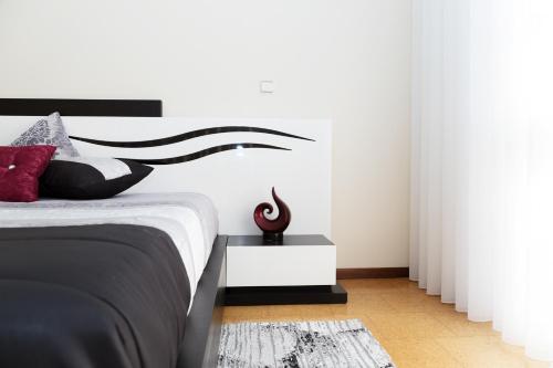 a bedroom with a bed with a black and white headboard at Mar Rosa in Aguçadoura