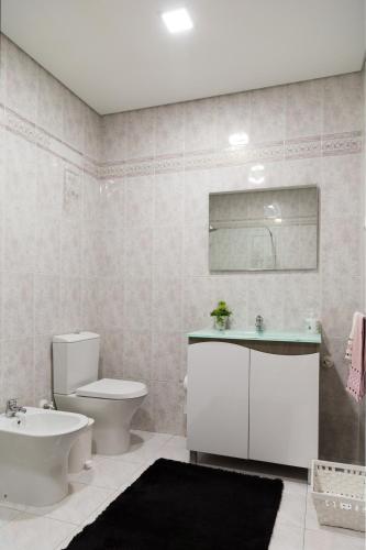 a bathroom with a toilet and a sink and a toilet istg at Mar Rosa in Aguçadoura