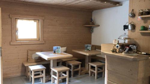 ヴァルフルヴァにあるAgriturismo Malga Dell'Alpeの2つのテーブルとスツールが備わるレストラン