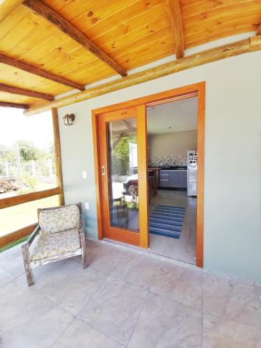 an open door to a patio with a chair at Pousada Origin in Guarda do Embaú