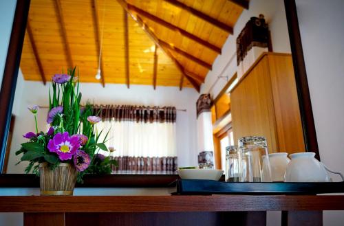 a table with a vase of purple flowers on it at SUNSET HILLS in Kandy
