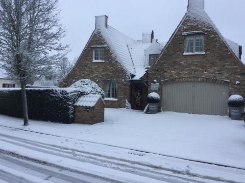 a house with a garage in the snow at B&B Colombe Blanche in Knokke-Heist