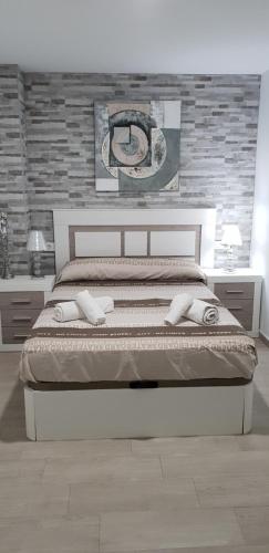 a bedroom with a bed and a brick wall at Apartamento NUEVO JEREZ BAHIA in Jerez de la Frontera