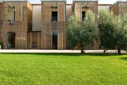 a brick building with trees in front of a lawn at Casale del Mare in Castiglioncello