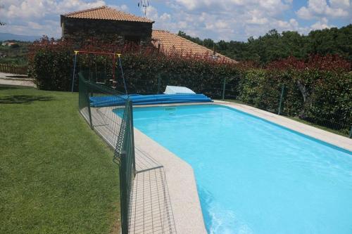 a large blue swimming pool in a yard at Casa do Poço - Douro in Peso da Régua