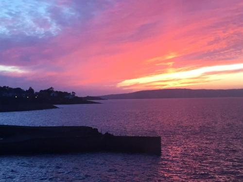 a sunset over a large body of water at Perfect getaway, seafront home in Bangor