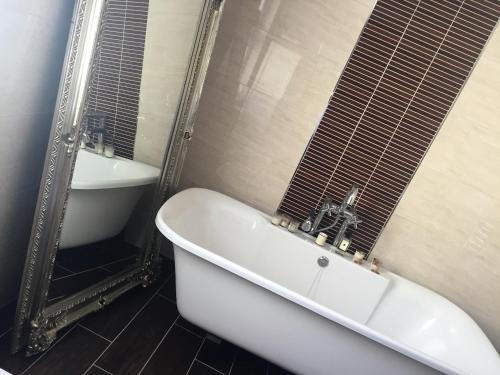 a white bath tub in a bathroom with a sink at Perfect getaway, seafront home in Bangor