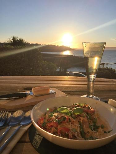 a bowl of food on a table with a glass of wine at Perfect getaway, seafront home in Bangor