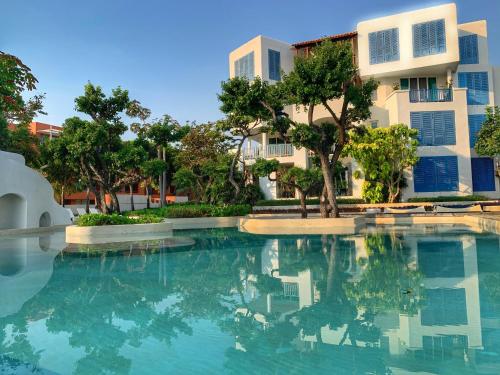 a swimming pool in front of a building at Chelona huahin beachfront condominium in Khao Tao