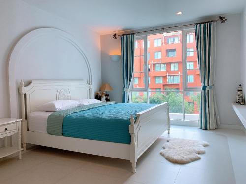 1 dormitorio con cama y ventana grande en Chelona huahin beachfront condominium en Khao Tao