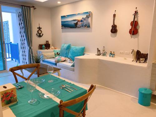 a dining room with a table and a guitar on the wall at Chelona huahin beachfront condominium in Khao Tao