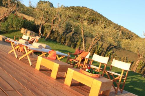 a group of chairs and tables on a wooden deck at I Veroni - Agriturismo and Wine Cellar in Pontassieve