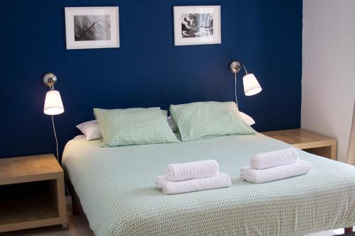 1 dormitorio azul con 1 cama con 2 toallas en Apartamentos Juan Benítez, en Cotillo