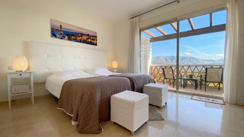 a bedroom with a bed and a view of a balcony at La Cala Golf Luxury TownHouse, frontline golf, spectacular views in La Cala de Mijas