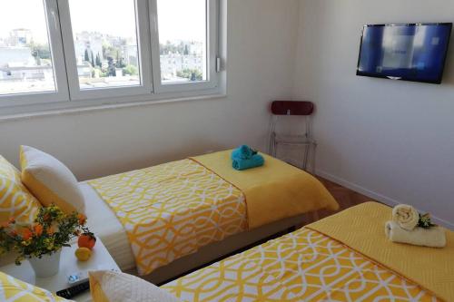 a room with two beds and a flat screen tv at Apartment Altitudo Split sea and city view terrace comfortable and new in Split
