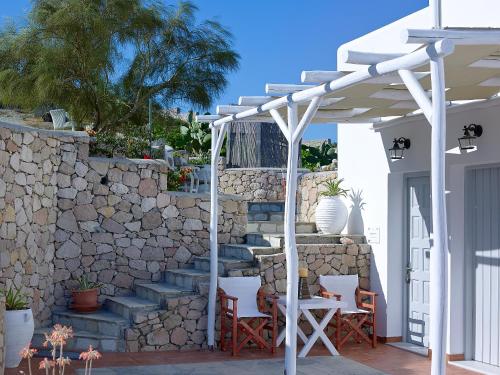 a white pergola on a patio with a stone wall at Villa Gallis in Pollonia