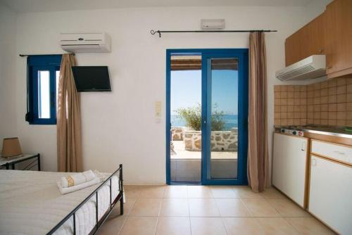 Habitación con cama y cocina con puerta abierta. en Kionia Apartments, en Kerames