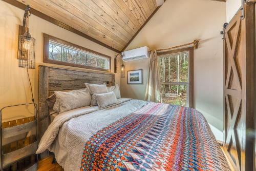 a bedroom with a bed and a large window at Smoky Mountain Tiny Home in Pigeon Forge