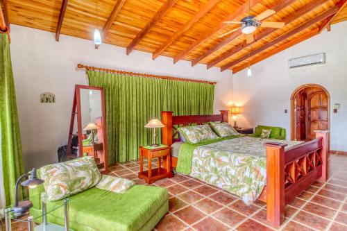 1 dormitorio con cama, sofá y espejo en Casa Margarita, en Playa Flamingo